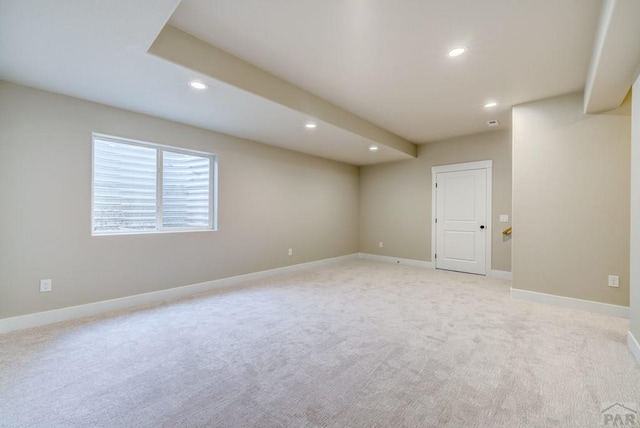 spare room featuring recessed lighting, light colored carpet, and baseboards