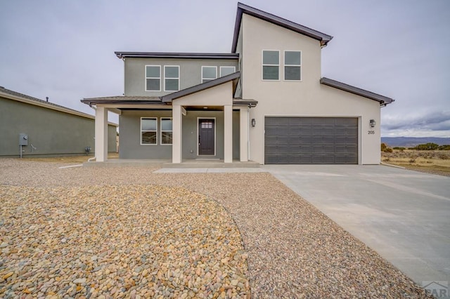 view of front of house featuring a garage, driveway, a porch, and stucco siding