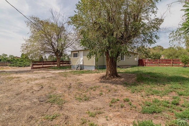 view of yard featuring entry steps and fence