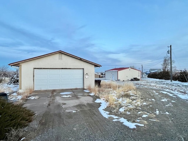 snow covered garage featuring a detached garage