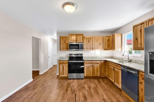 1510 24 1/4 Ln, Pueblo, CO 81006 - kitchen with appliances with stainless steel finishes, a sink, light wood-style flooring, and light stone countertops