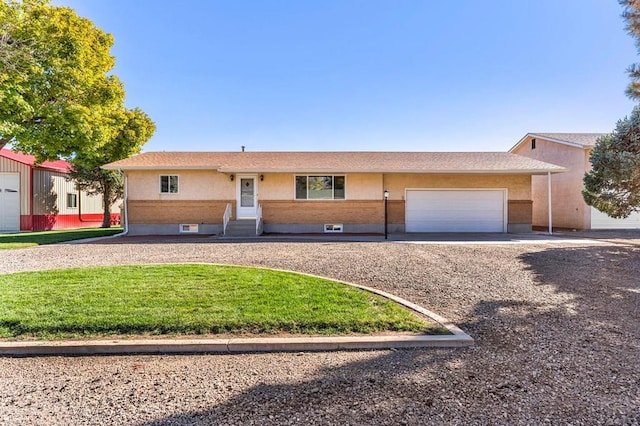 1510 24 1/4 Ln, Pueblo, CO 81006 - ranch-style home featuring an attached garage, curved driveway, a front lawn, and entry steps