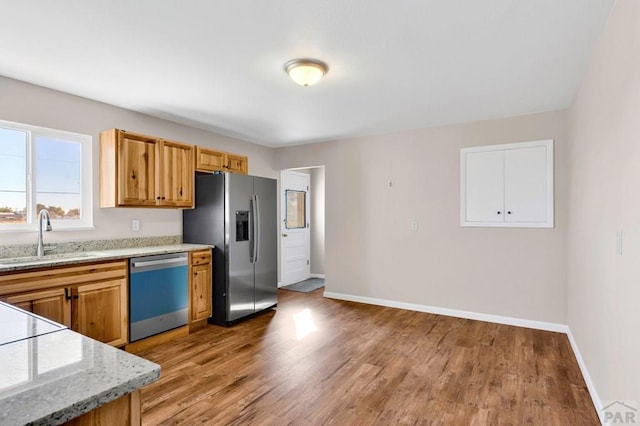 1510 24 1/4 Ln, Pueblo, CO 81006 - kitchen with dishwashing machine, a sink, stainless steel refrigerator with ice dispenser, light wood-style floors, and baseboards