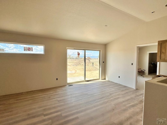 962 E Sandusky Dr, Pueblo West, CO 81007 - spare room featuring lofted ceiling and light wood-style floors