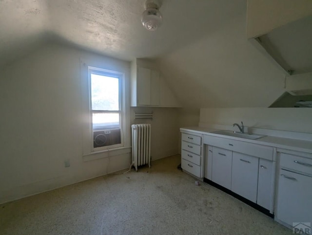 bonus room with radiator heating unit, vaulted ceiling, and a sink