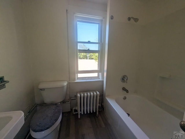 full bathroom with toilet, radiator heating unit, wood finished floors, and shower / bathing tub combination