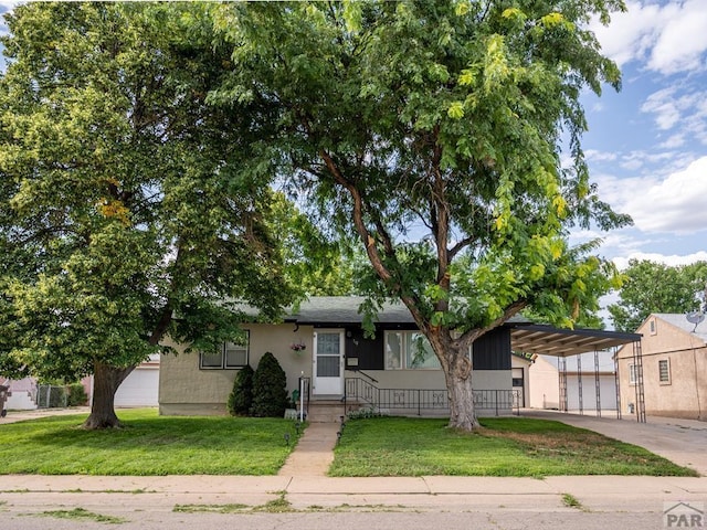 single story home featuring a front yard, an attached carport, concrete driveway, and stucco siding