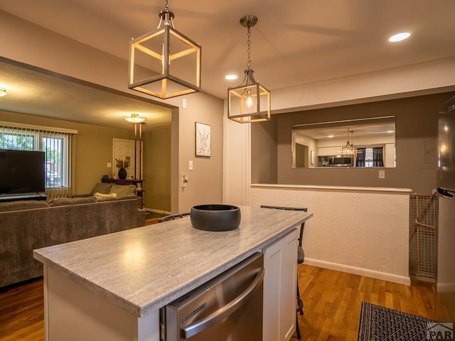 kitchen with open floor plan, hanging light fixtures, a kitchen island, and light countertops