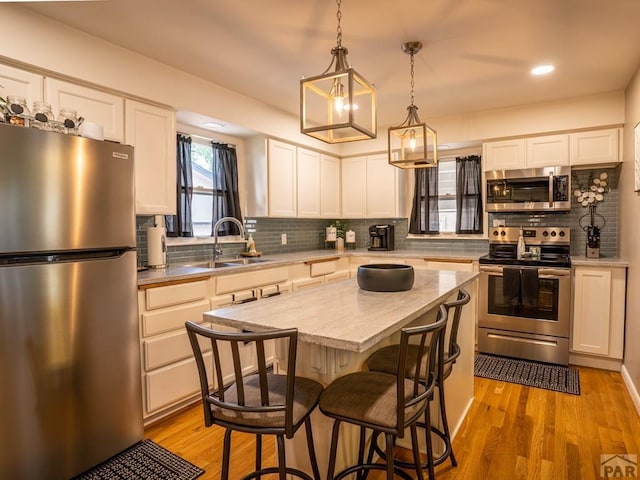 kitchen featuring a kitchen island, appliances with stainless steel finishes, and white cabinets