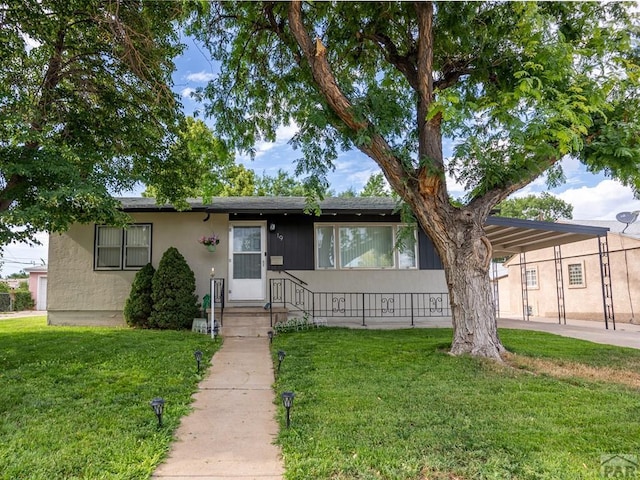 ranch-style house featuring an attached carport, a front lawn, and stucco siding