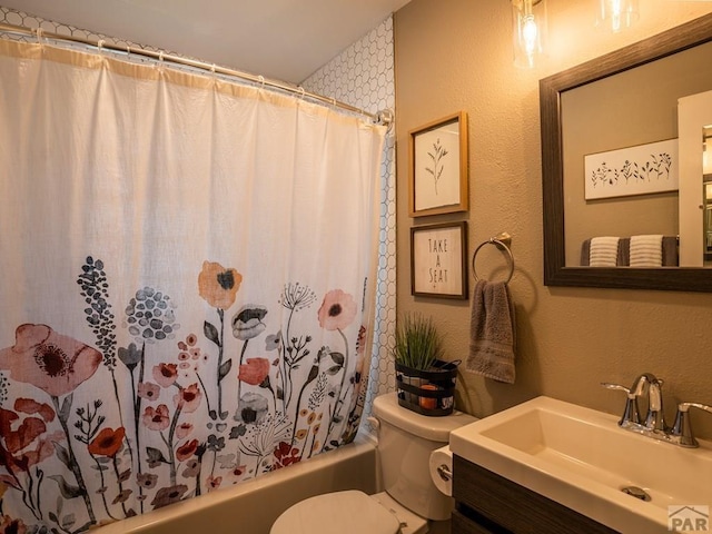 bathroom with toilet, a textured wall, shower / bathtub combination with curtain, and vanity