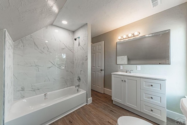 bathroom featuring vanity, wood finished floors, visible vents, shower / tub combination, and toilet