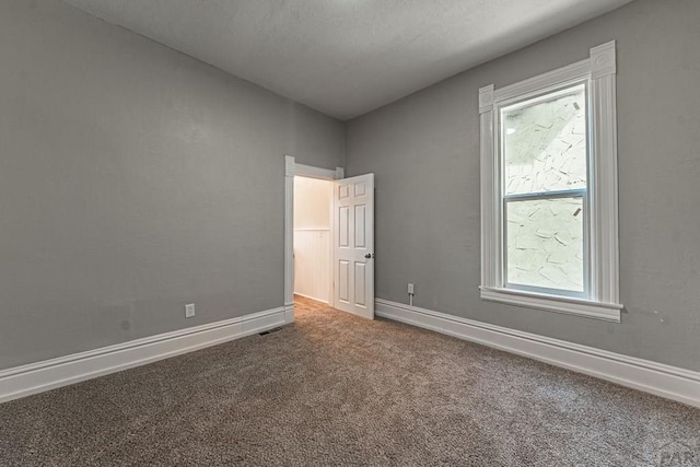 unfurnished room featuring carpet flooring and baseboards