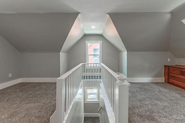 stairway featuring baseboards, carpet flooring, and vaulted ceiling