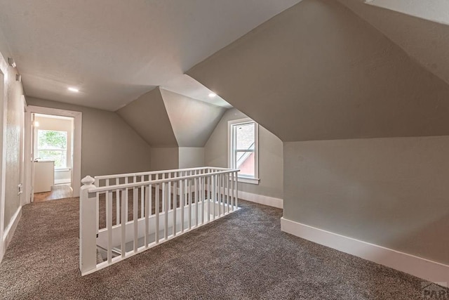 additional living space featuring vaulted ceiling, carpet flooring, and baseboards