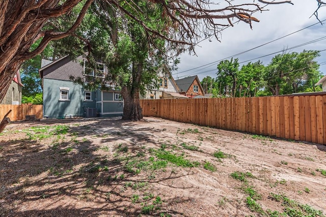 view of yard with central AC unit and a fenced backyard