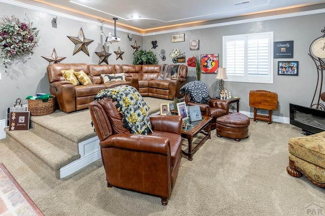 living room with ornamental molding, a tray ceiling, carpet flooring, and baseboards