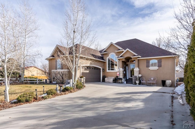 view of front of home with a garage, concrete driveway, central AC unit, and stucco siding