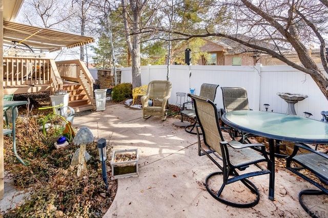 view of patio featuring a fenced backyard, a deck, and outdoor dining space