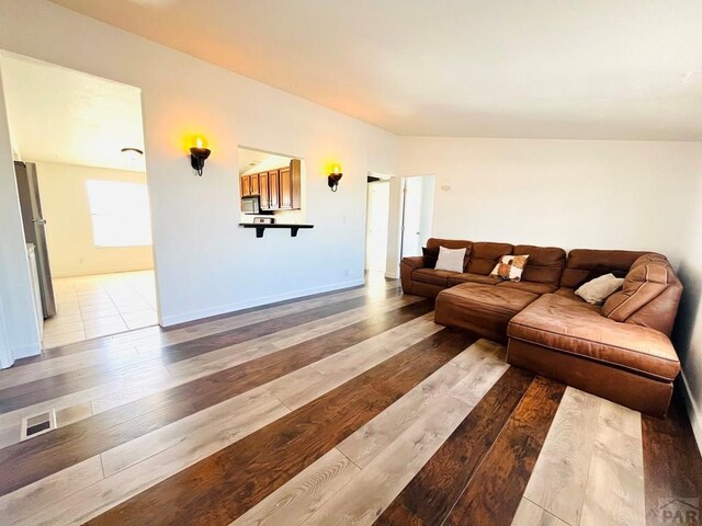 living area with light wood-type flooring and baseboards