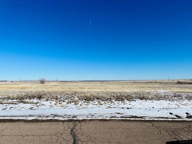 view of snow covered land featuring a rural view