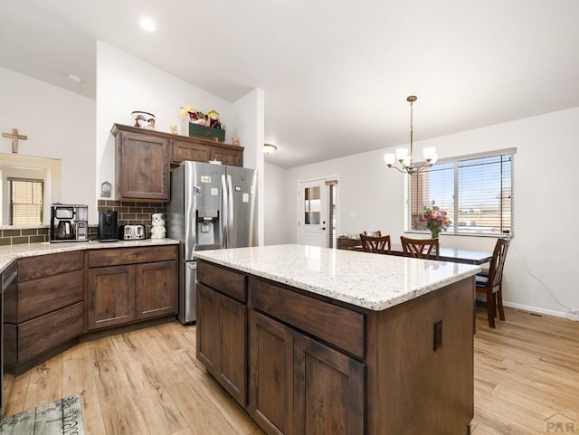 1700 Kingfisher Ln, Pueblo, CO 81008 - kitchen with stainless steel fridge, a chandelier, light wood-style floors, and hanging light fixtures