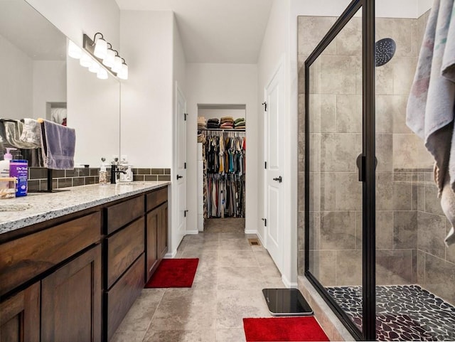 1700 Kingfisher Ln, Pueblo, CO 81008 - full bath with vanity, a shower stall, a spacious closet, and baseboards