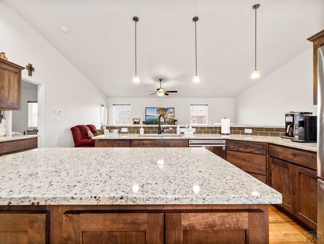1700 Kingfisher Ln, Pueblo, CO 81008 - kitchen with lofted ceiling, dishwasher, a kitchen island, a sink, and plenty of natural light
