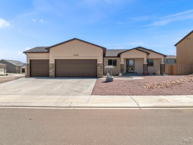 1700 Kingfisher Ln, Pueblo, CO 81008 - ranch-style house featuring stone siding, an attached garage, stucco siding, and concrete driveway