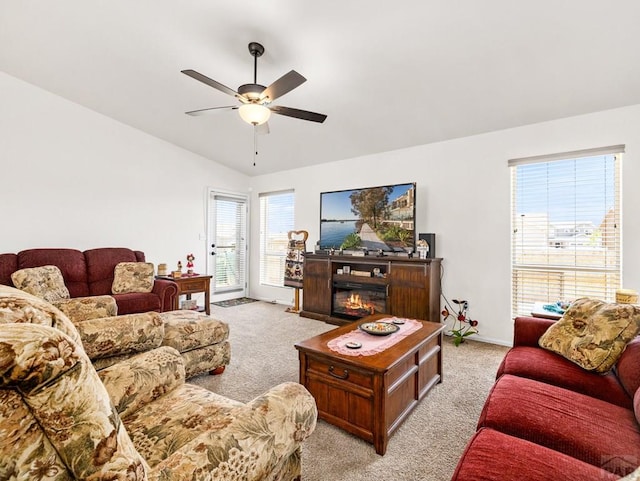 1700 Kingfisher Ln, Pueblo, CO 81008 - living room with light colored carpet, ceiling fan, vaulted ceiling, baseboards, and a glass covered fireplace