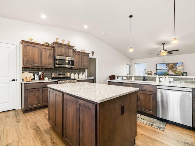 1700 Kingfisher Ln, Pueblo, CO 81008 - kitchen featuring appliances with stainless steel finishes, lofted ceiling, light wood-style floors, a center island, and a sink