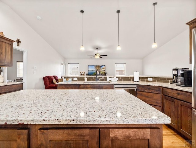 1700 Kingfisher Ln, Pueblo, CO 81008 - kitchen with lofted ceiling, dishwasher, a kitchen island, a sink, and plenty of natural light