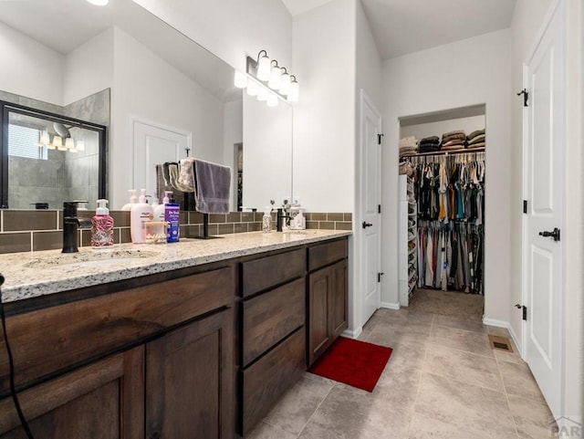 1700 Kingfisher Ln, Pueblo, CO 81008 - full bathroom featuring a stall shower, double vanity, a spacious closet, and baseboards