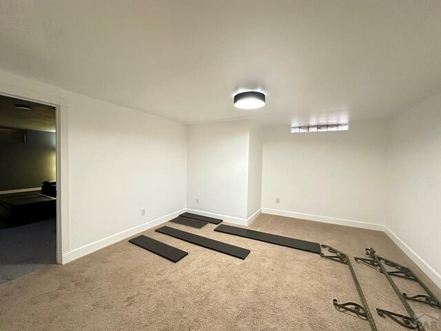 carpeted empty room featuring baseboards