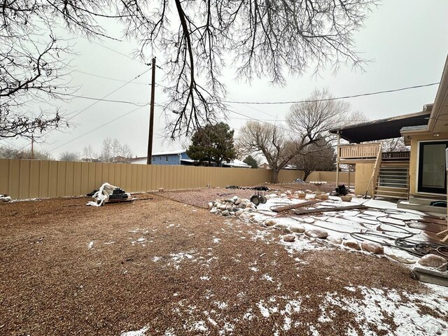 snowy yard featuring stairway and fence