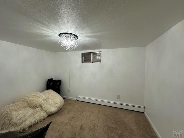 interior space featuring a textured ceiling, a baseboard radiator, carpet flooring, and baseboards