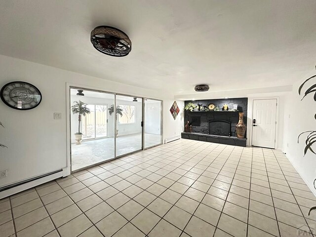 unfurnished living room with a baseboard radiator, a fireplace with raised hearth, and light tile patterned flooring