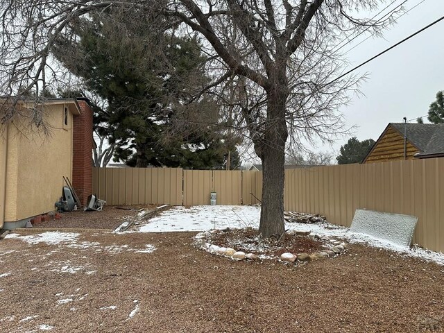 snowy yard featuring fence