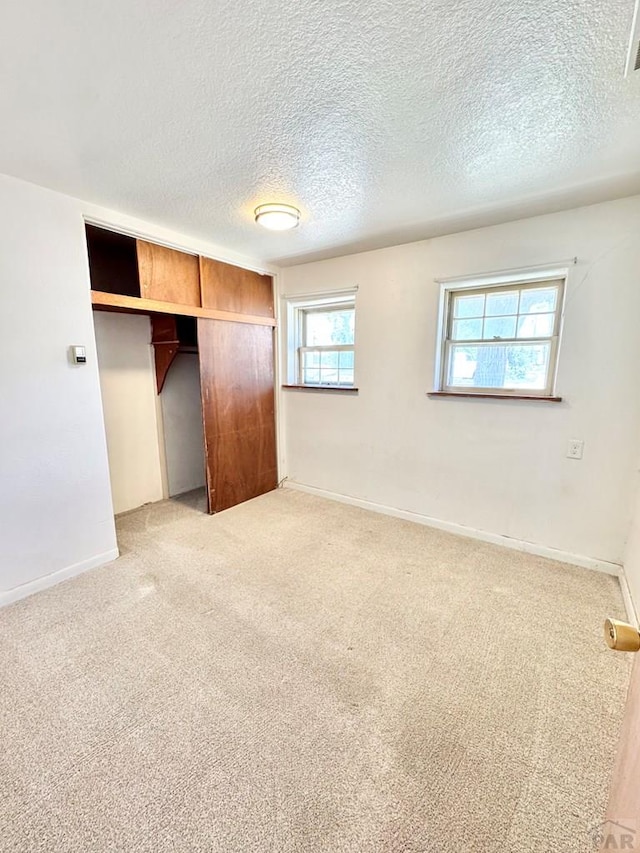 209 Beymer, Cheraw, CO 81030 - unfurnished bedroom featuring light colored carpet, a closet, and a textured ceiling