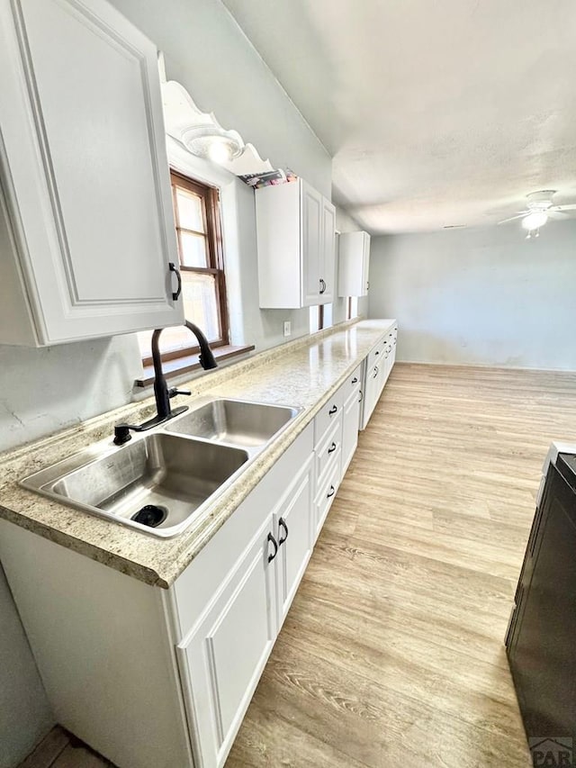 209 Beymer, Cheraw, CO 81030 - kitchen featuring white cabinets, light wood finished floors, light countertops, and ceiling fan