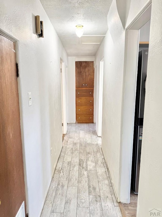 209 Beymer, Cheraw, CO 81030 - corridor with a textured ceiling, a textured wall, and light wood-style flooring