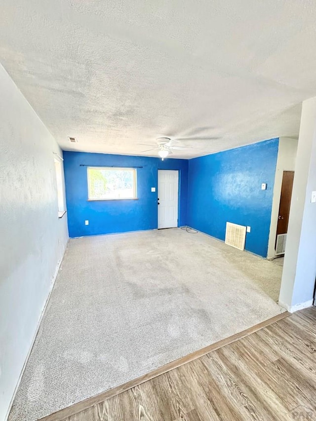 209 Beymer, Cheraw, CO 81030 - empty room with a textured ceiling, wood finished floors, ceiling fan, and carpet floors
