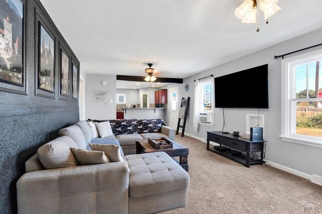 living room featuring carpet floors, baseboards, and a ceiling fan