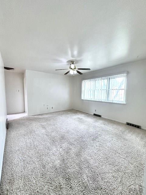 unfurnished room with visible vents and a ceiling fan