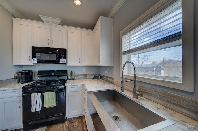 kitchen featuring ornamental molding, white cabinetry, a sink, and black appliances