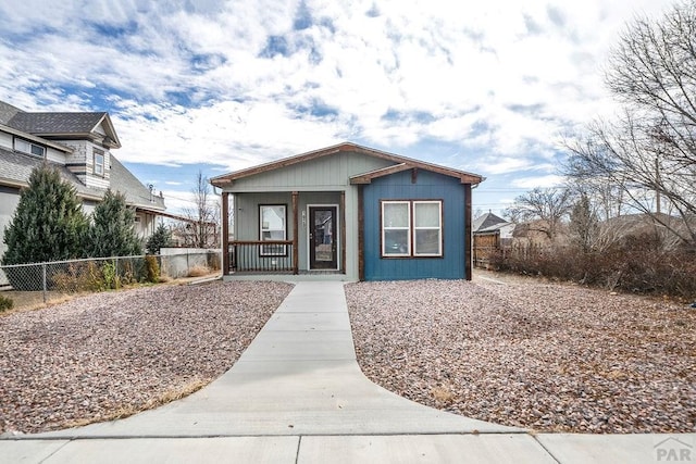 bungalow-style home with covered porch and fence