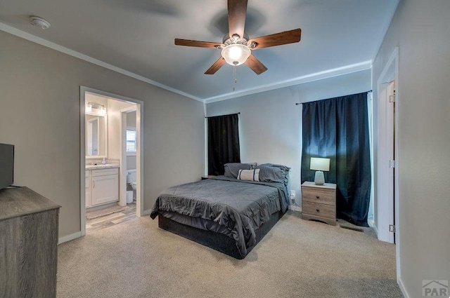 bedroom with crown molding, light colored carpet, a sink, ensuite bath, and baseboards