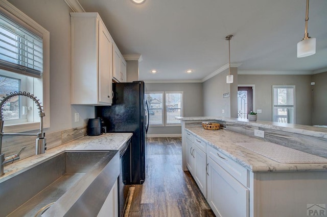 kitchen featuring ornamental molding, a sink, white cabinets, and pendant lighting