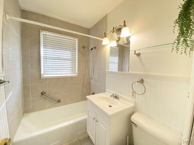 1624 Garwood Dr, Pueblo, CO 81005 - full bathroom featuring washtub / shower combination, vanity, healthy amount of natural light, tile patterned flooring, and wainscoting
