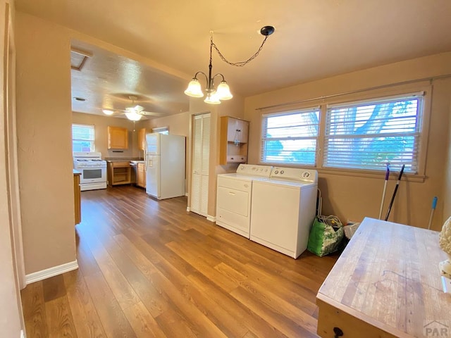 1624 Garwood Dr, Pueblo, CO 81005 - kitchen featuring white appliances, washing machine and dryer, plenty of natural light, and dark wood-style floors
